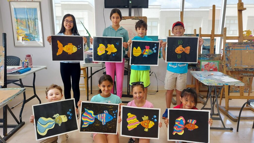 A group of children holding up art

Description automatically generated