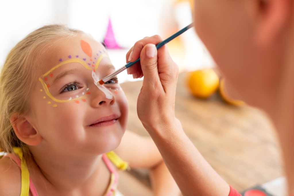 A child getting her face painted

Description automatically generated